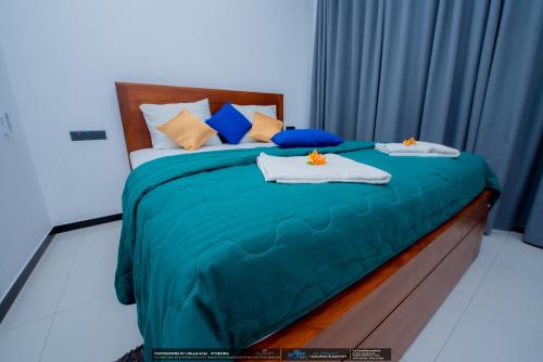 a bedroom with a bed with blue sheets and pillows at BLUE WHALES HOTEL in Hikkaduwa
