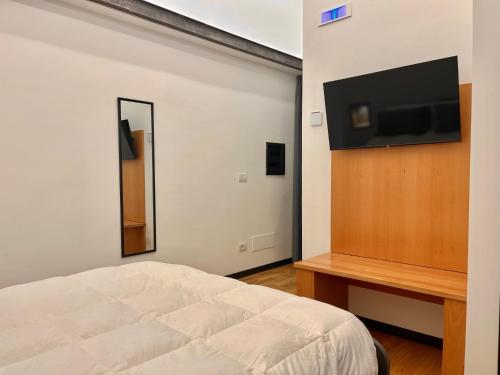Un dormitorio con una cama y un televisor de pantalla plana. en Dimore diffuse R H, en Rende