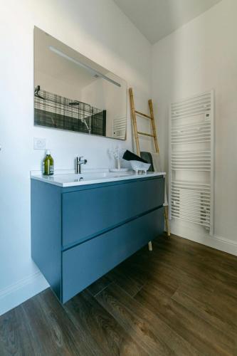 une salle de bain avec un lavabo bleu et un miroir dans l'établissement Maison spacieuse et jardin proche Soulages WisdhomeConciergerie, à Rodez