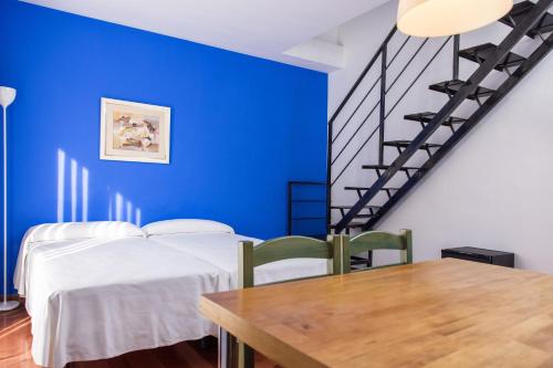 a blue room with two beds and a wooden table at RVHotels Mar de Tossa in Tossa de Mar