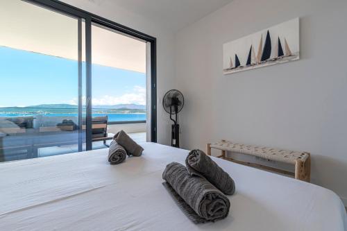 - une chambre avec un lit et des serviettes de toilette dans l'établissement A Sereina - appt climatisé proche de la plage, à Grosseto-Prugna