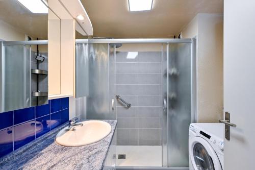 a bathroom with a sink and a washing machine at L'Appart du Marché - A quelques min de la plage in Pornichet
