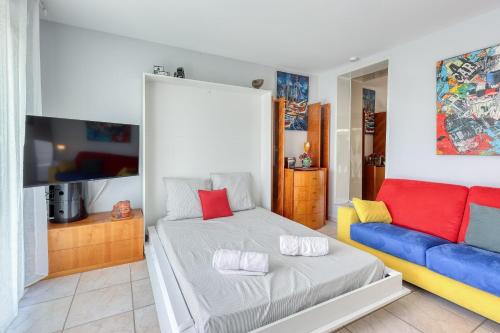 une chambre avec un lit et un canapé dans l'établissement Le Toy Palm - 5min à Pied de la Plage, à Sanary-sur-Mer