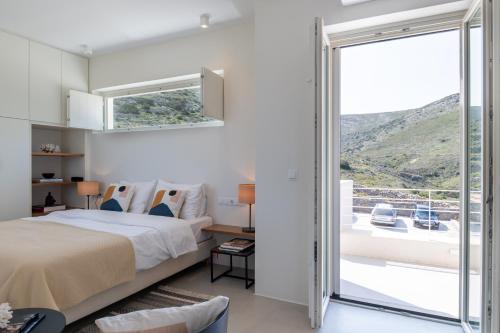 a bedroom with a large bed and a balcony at Noble 7 Suites - Adults Only - Onar Hotels Collection in Parikia