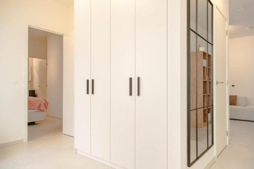 a room with white cabinets and a mirror at Serene Apartment in the Heart of Antwerp in Antwerp