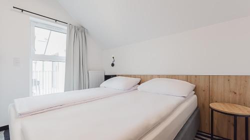 a white bed in a room with a window at VacationClub - Green Port Apartament 506 in Kołobrzeg