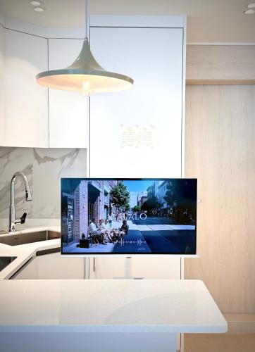 a kitchen with a flat screen tv on a kitchen counter at HausKomma 서울 홍대,이태원,명동 짐보관 무료 주차 엘레베이터 새아파트 in Seoul