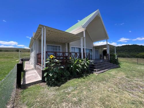 a small white house with a porch and a fence at Roydon Reserve in Queenstown