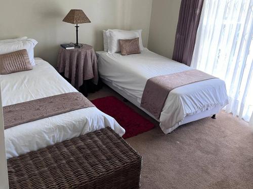 a room with two beds and a table with a lamp at Roydon Reserve in Queenstown