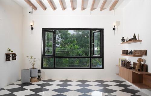 a room with a large window and a checkered floor at Hotel River View in Tiruchchirāppalli