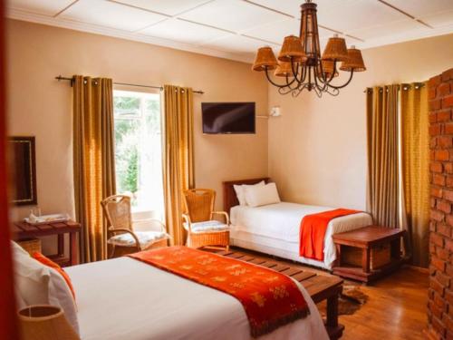a bedroom with two beds and a chandelier at Roydon Reserve in Queenstown