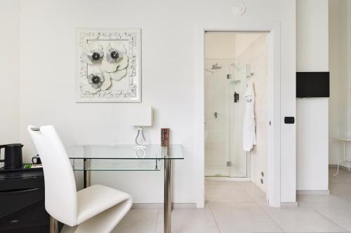a white room with a glass table and a white chair at Boutique Hotel San Giovanni in San Giovanni in Persiceto