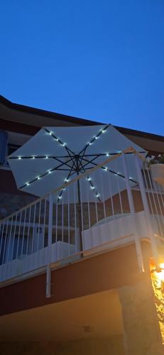 a patio umbrella with lights on top of a building at homeliday ACTIVE in Caldana