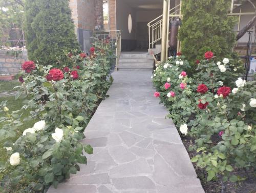 a garden of roses in front of a house at Guest house Hasmik in Yeghegnadzor