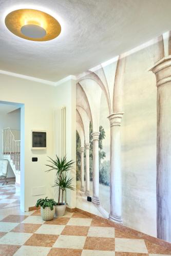 a hallway with a painting of columns on the wall at Boutique Hotel San Giovanni in San Giovanni in Persiceto