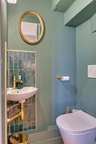 une salle de bain avec un lavabo, des toilettes et un miroir dans l'établissement Adorable maison de 75m2 avec grande terrasse et barbecue - 3 chambres, à Touques
