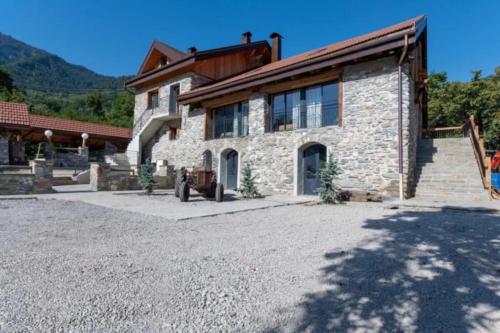 une maison en pierre avec une grande allée en face de celle-ci dans l'établissement Chalet La Sentinelle, à Bellecombe