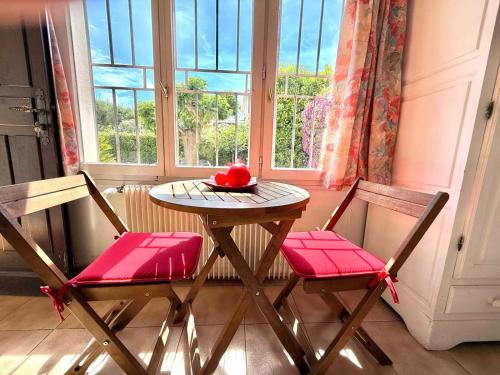 une table et deux chaises dans une pièce avec une fenêtre dans l'établissement Maison 3 pieces, à Villeneuve-Loubet