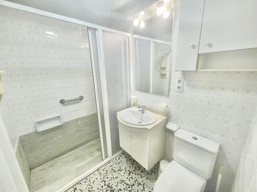 a white bathroom with a toilet and a shower at La Solana in Roses