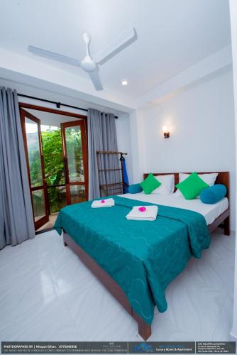 a bedroom with a large bed and a window at BLUE WHALES HOTEL in Hikkaduwa