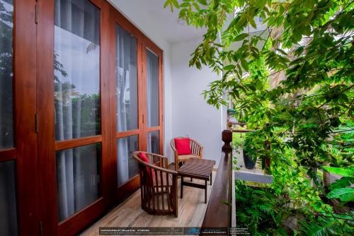 a balcony with a chair and a window at BLUE WHALES HOTEL in Hikkaduwa