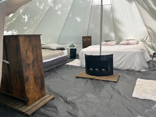 - une chambre avec 2 lits et une cheminée dans une tente dans l'établissement Séjour insolite sur une île, à Ézy-sur-Eure