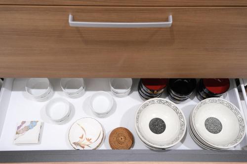 a drawer filled with plates and bowls and cups at 鎌倉 江ノ島 新築貸切一戸建て全館浄水システム完備 海近く 江ノ島が見える 露天テラス 無料駐車2台付 in Kamakura