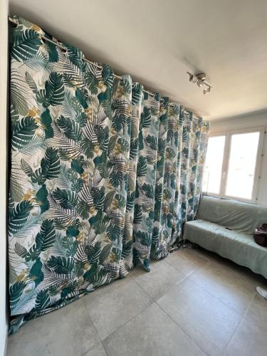 - un salon avec des rideaux et un canapé dans l'établissement Appartement rénové Toulon, à Toulon