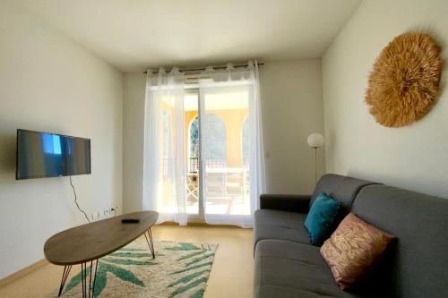 a living room with a couch and a table at Les Naïades C12 - 2 bedrooms for 5 people ! in Avène