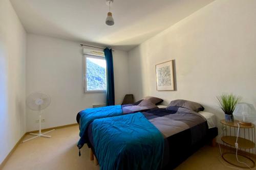 a bedroom with a bed with blue sheets and a window at Les Naïades C12 - 2 bedrooms for 5 people ! in Avène