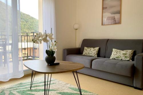ein Wohnzimmer mit Sofa und Tisch in der Unterkunft Les Naïades A01 - 2 bedrooms for 6 people ! in Avène