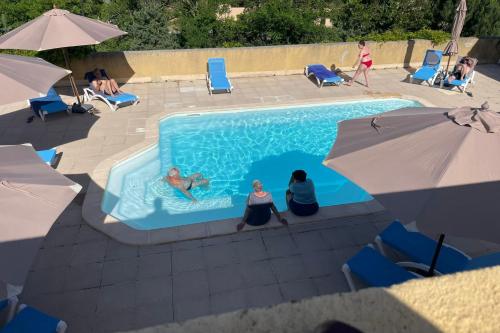 eine Gruppe von Menschen sitzt in einem Schwimmbecken in der Unterkunft Les Naïades A01 - 2 bedrooms for 6 people ! in Avène
