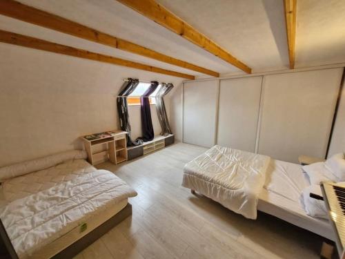 une chambre avec deux lits et une fenêtre dans l'établissement Grande maison de village avec piscine chauffée, à Faucon-de-Barcelonnette
