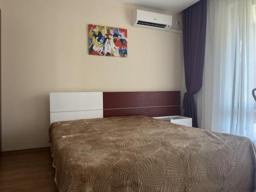 a bedroom with a bed and a picture on the wall at PREMIER HOUSE BEACH Hotel in Sveti Vlas