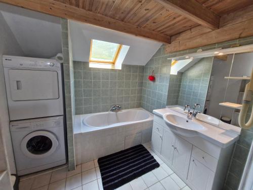 une salle de bain avec une machine à laver et un lavabo dans l'établissement Grande maison de village avec piscine chauffée, à Faucon-de-Barcelonnette