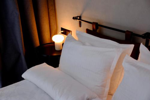 een slaapkamer met 2 bedden met witte kussens en een lamp bij Eleve Residences - Stone Studios in Sofia