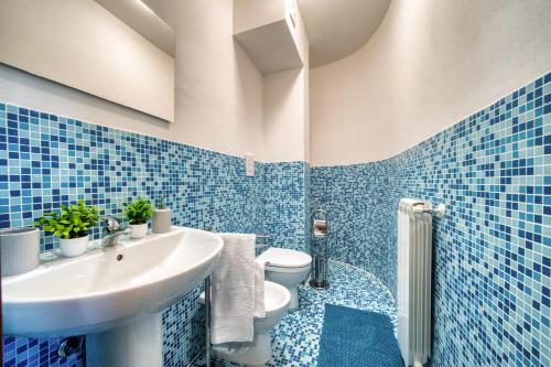 ein blau gefliestes Badezimmer mit Waschbecken und Toilette in der Unterkunft Chiara's flat in Laiatico