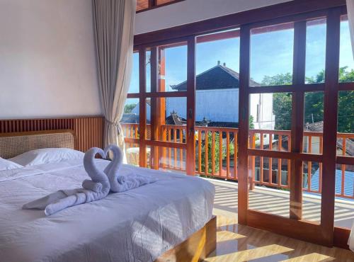 a bedroom with a bed with a view of a balcony at Villa Nuansa Indah 2BR UNGASAN in Uluwatu