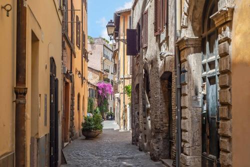 an alley in an old town with flowers at Essence Collection Hotel in Rome