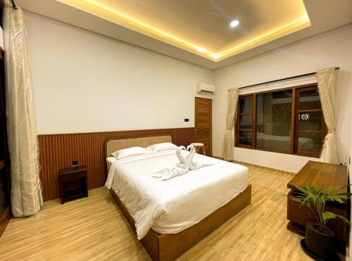 a bedroom with a bed with a robe on it at Villa Nuansa Indah 2BR UNGASAN in Uluwatu