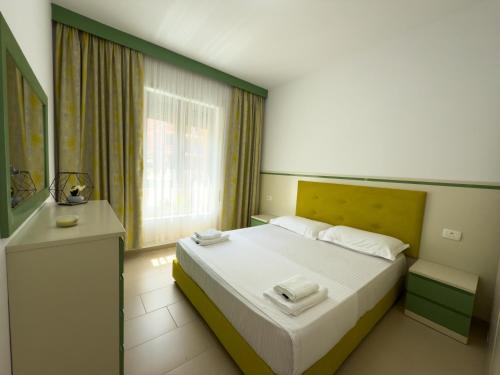 Un dormitorio con una cama con dos toallas encima. en Lovely Apartment, en Vlorë