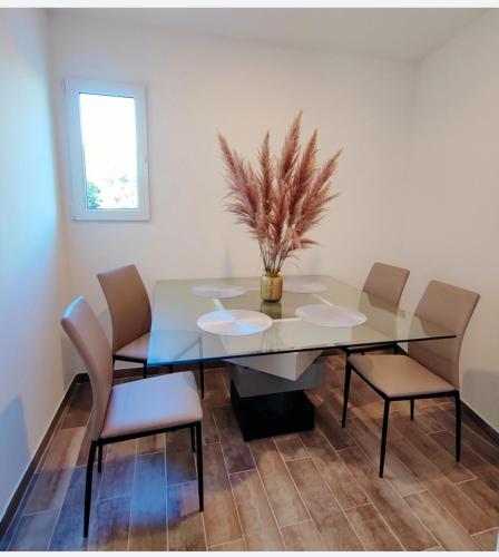 une salle à manger avec une table et des chaises en verre dans l'établissement Jolie Maison-6 personnes, à Argelès-sur-Mer