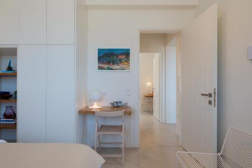 a white room with a table and a chair at Noble 7 Suites - Adults Only - Onar Hotels Collection in Parikia