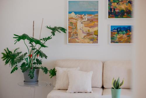 a living room with a couch and paintings on the wall at Noble 7 Suites - Adults Only - Onar Hotels Collection in Parikia