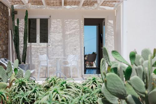 a room with plants and a table and chairs at Noble 7 Suites - Adults Only - Onar Hotels Collection in Parikia