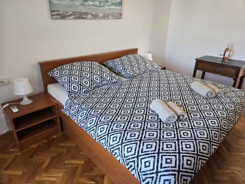 a bed with a black and white comforter in a bedroom at Apartments Manta in Pag