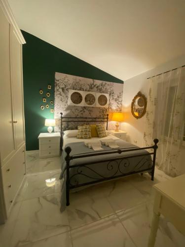 a bedroom with a bed and a green wall at Da Tea in San Teodoro