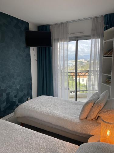 une chambre avec un lit et une grande fenêtre dans l'établissement Cannes Beach Residence vue mer et pisicne, à Cannes