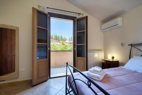 ein Schlafzimmer mit einem Bett und einem großen Fenster in der Unterkunft Chiara's flat in Laiatico