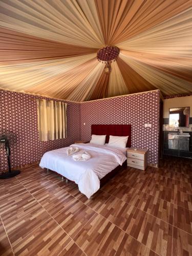 a bedroom with a large bed with a ceiling at Sand Star Camp in Wadi Rum